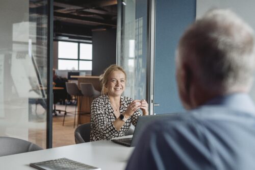 Two people talking casually on a sofa
