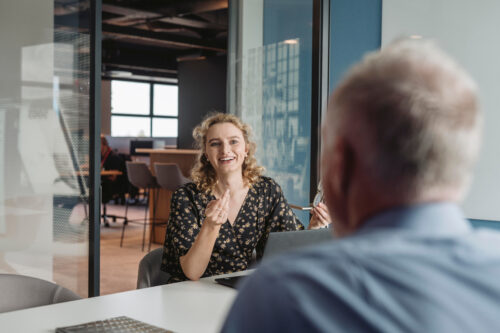 two people talking at desk